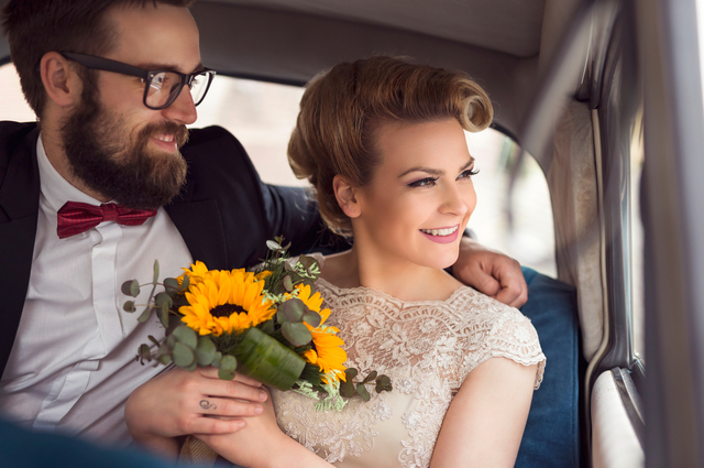 happy couple being driven away for their honeymoon